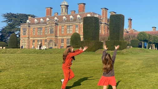 Two children playing in the Gardens with Sudbury Hall in the background